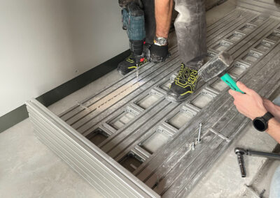 Tecnico fissa al solaio la base di un dispositivo ISAAC nel sottotetto del complesso residenziale