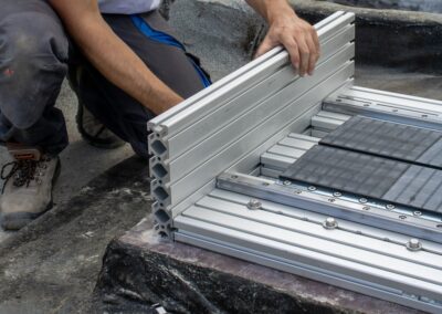 Tecnico assembla il profilo in alluminio della guida di un dispositivo ISAAC sul tetto della scuola