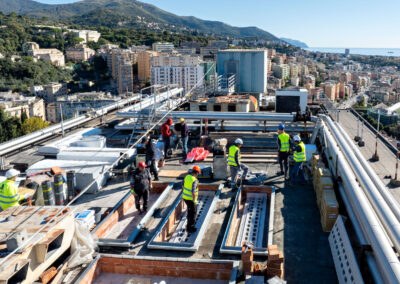 Cantiere di adeguamento sismico sul tetto dell'Ospedale San Martino, con Genova e il mare sullo sfondo