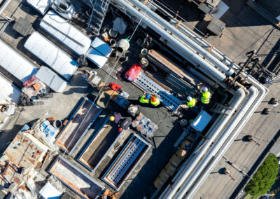 Vista dall'alto della copertura del Monoblocco dell'Ospedale San Martino con operai al lavoro sui dispositivi ISAAC
