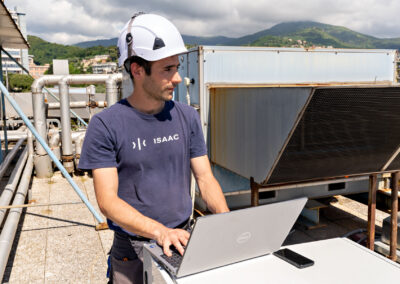 Tecnico ISAAC al lavoro al computer accanto al sistema di protezione sismica sul tetto del Padiglione Specialità