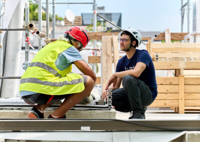 Due tecnici al lavoro sulla guida di un dispositivo ISAAC sul tetto dell'edificio per uffici a Milano
