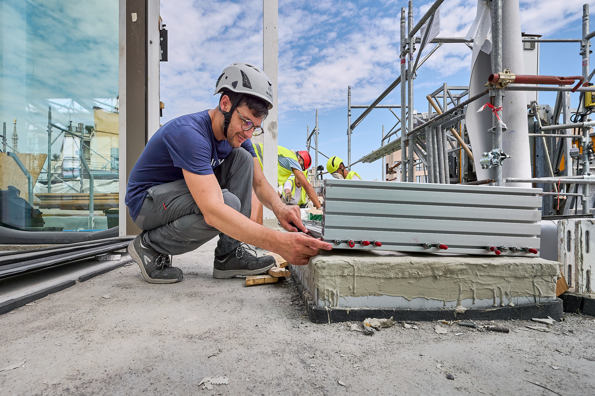 Tecnico posiziona un pacco di piastre in acciaio su una base in calcestruzzo sul tetto, a Milano