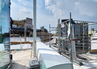 Dispositivi ISAAC con coperture bianche sul terrazzo dell'edificio per uffici, accanto ai ponteggi, a Milano