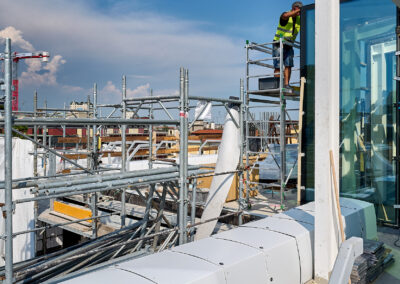 Cantiere in copertura con ponteggi e coperture dei dispositivi ISAAC sull'edificio per uffici di Milano