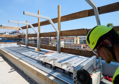 Tecnico controlla massa e guida di un dispositivo ISAAC durante l'installazione in copertura a Milano