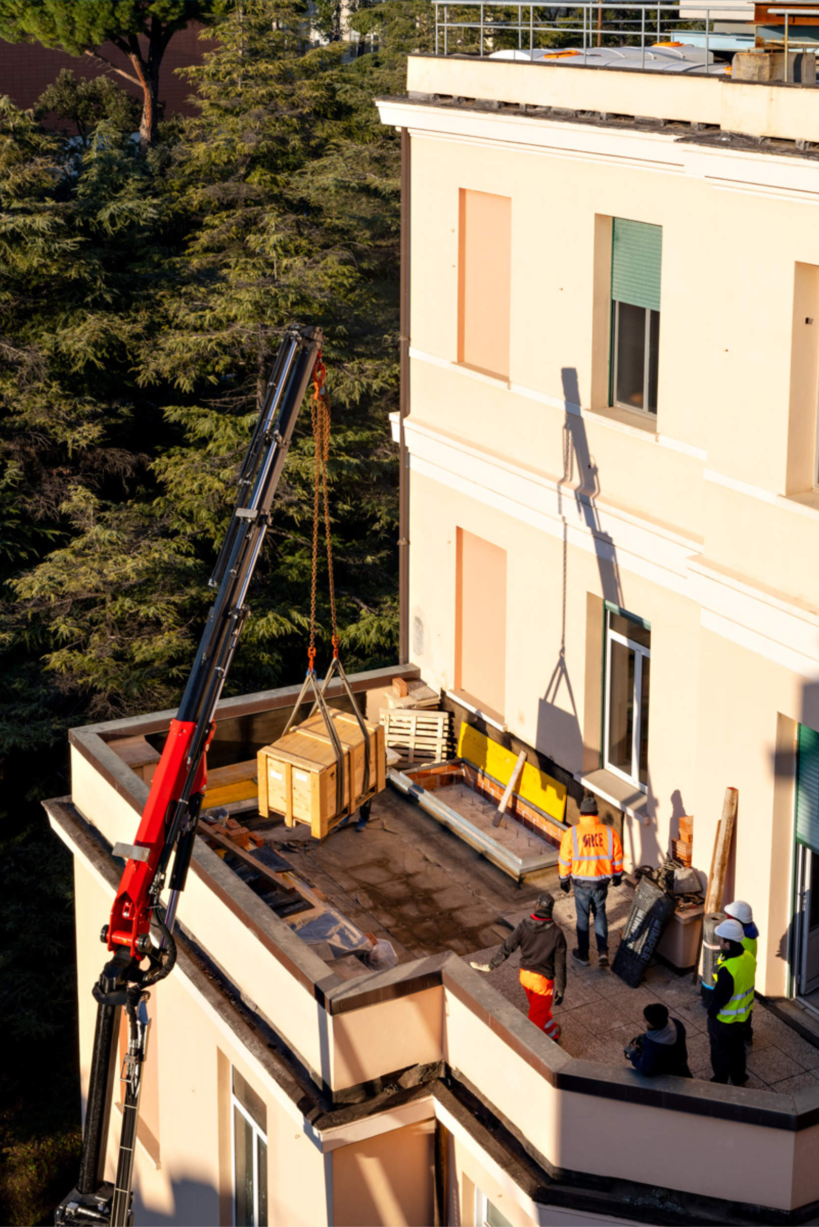Installazione non invasiva dei dispositivi antisismici ISAAC sul tetto dell'edificio tramite autogru senza interrompere l'operatività